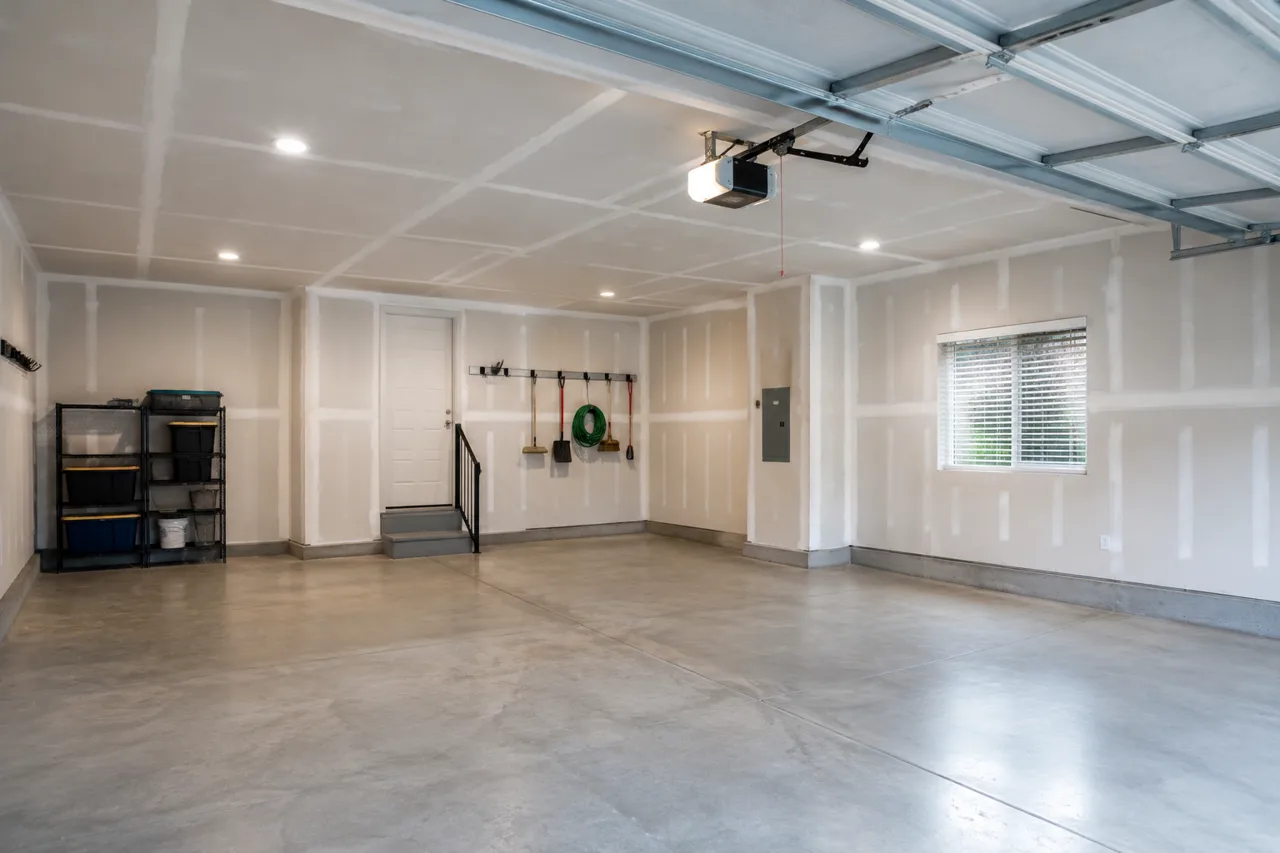 Finished two-car garage with drywalled and taped walls and ceiling, recessed lights and a polished concrete floor